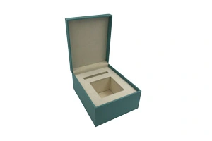 An open custom teal-colored luxury rigid box for jewelry with cream suede interior and embossed KAGAMI logo. Manufactured by ZY Pack, a premium rigid folding box manufacturer in Wenzhou, China, offering ISO-9001 and FSC-certified packaging solutions