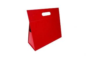 A stylish red trapezoidal rigid folding box featuring a built-in die-cut handle for easy carrying. This innovative hybrid packaging is engineered by ZY Pack in Wenzhou, China, combining 15 years of expertise to offer high-end, space-saving solutions for luxury retail brands