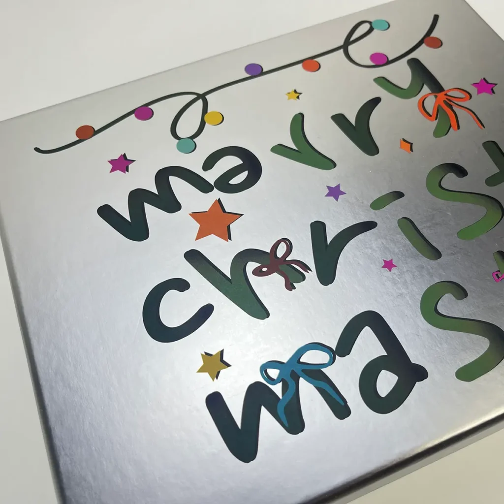 Macro close-up of UV printing on silver metallic paper showing sharp text and high-saturation ink without spray powder artifacts.