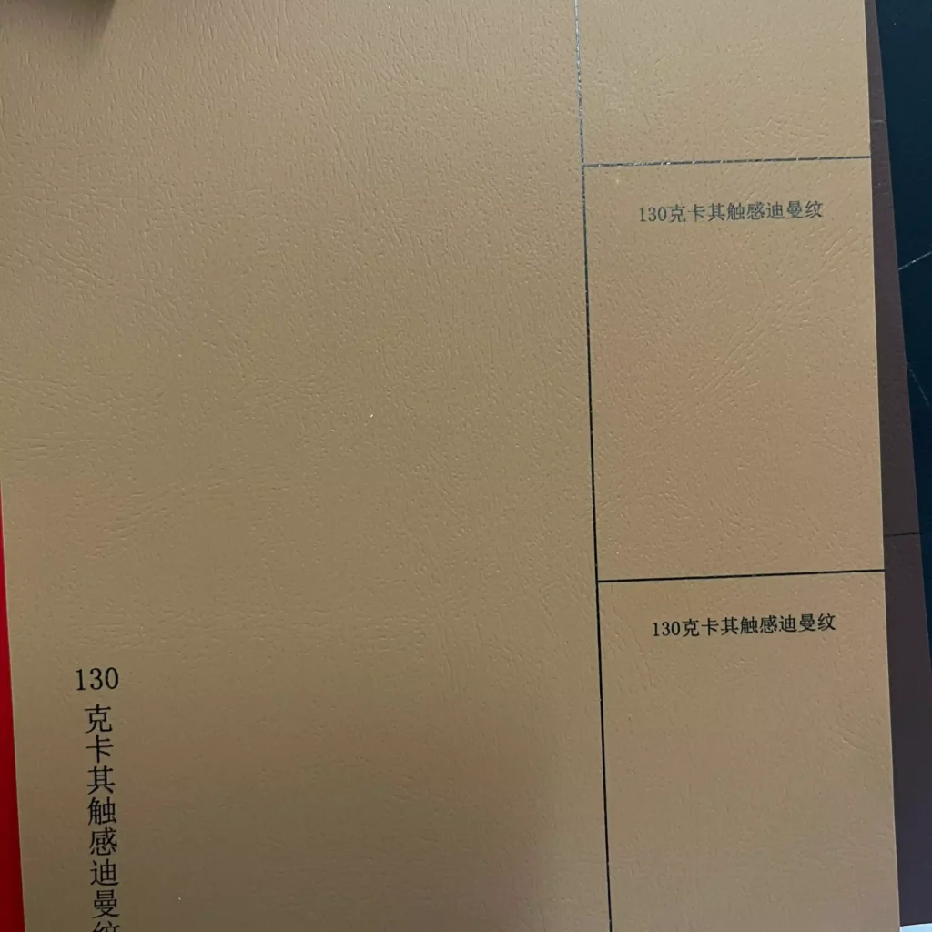 Close-up of 130g gsm textured soft-touch paper by ZY Pack, featuring a fingerprint-resistant Diman grain for luxury packaging