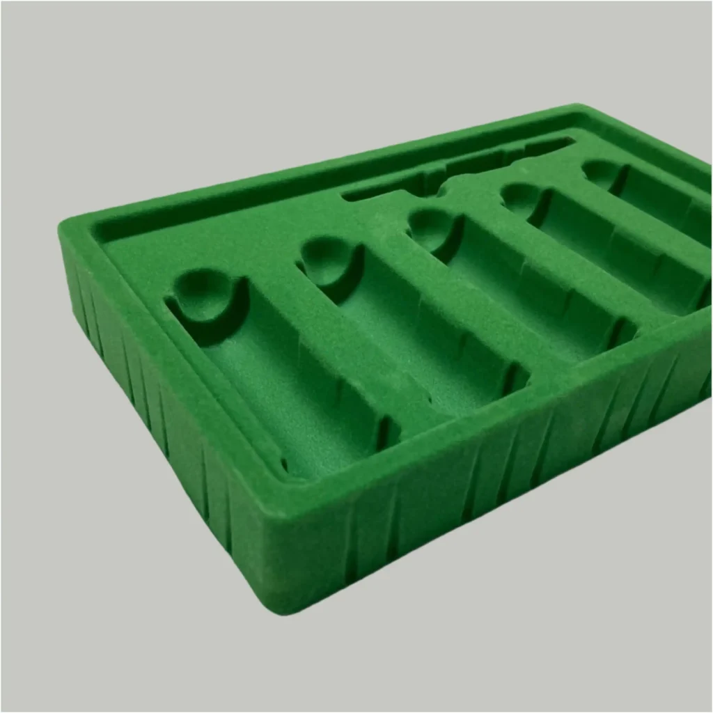 Custom green flocked blister tray with a velvet-like spray coating on a PS plastic base. A cost-effective alternative to flocked foam for cosmetic tools.