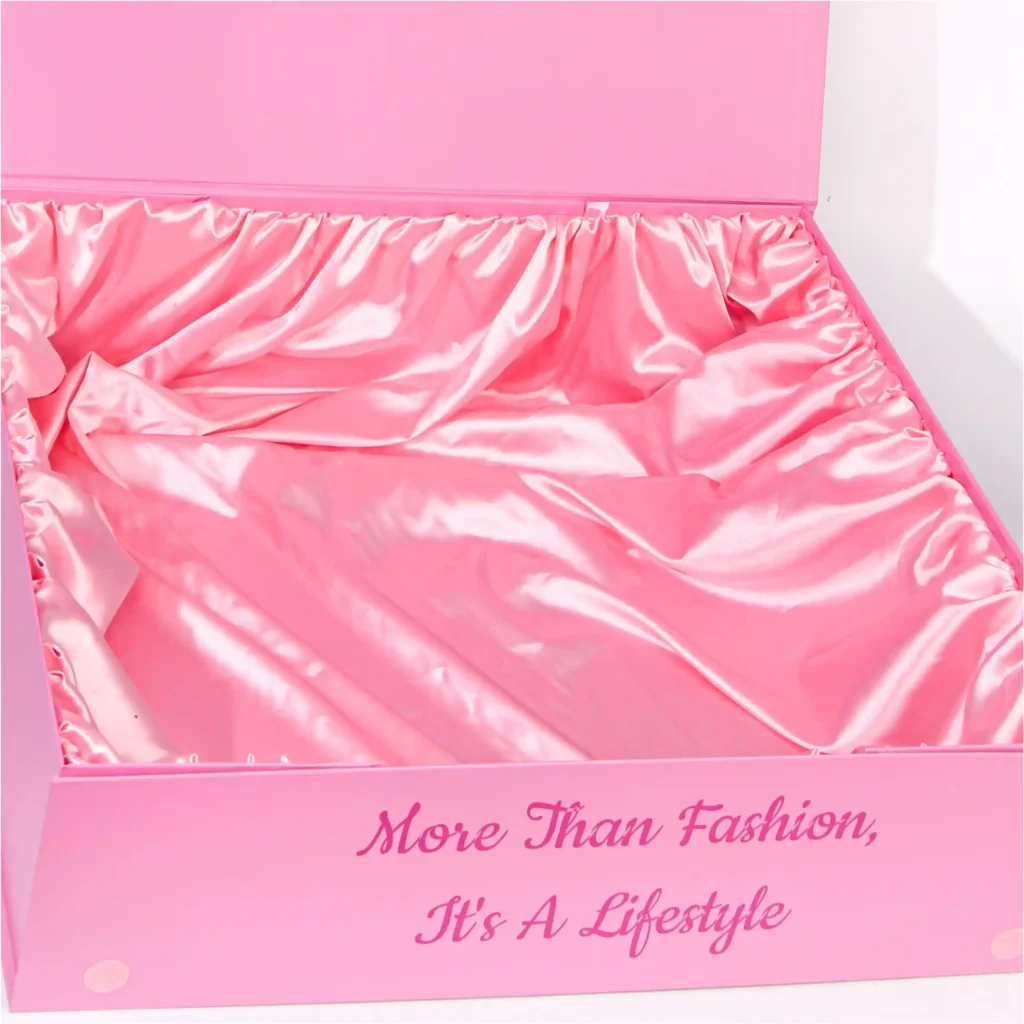 Open luxury pink gift box featuring a loose satin cloth lining draped over the base. Includes a custom printed logo on the lid. Elegant packaging for fashion and lingerie.