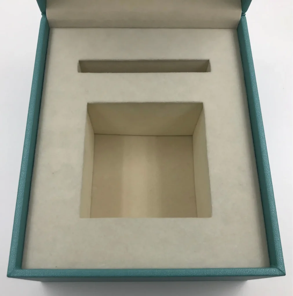 Custom teal jewelry box insert with a deep rectangular compartment. Constructed from a rigid foam block fully wrapped in microfiber cloth, combining structure with a luxury finish.