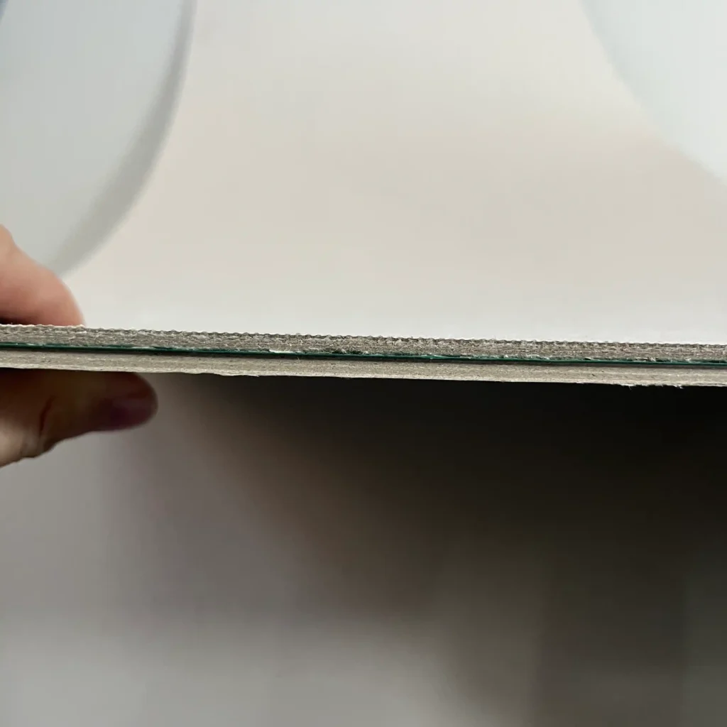 Macro shot of paperboard cross-section revealing internal fiber grain alignment and high-density structure.