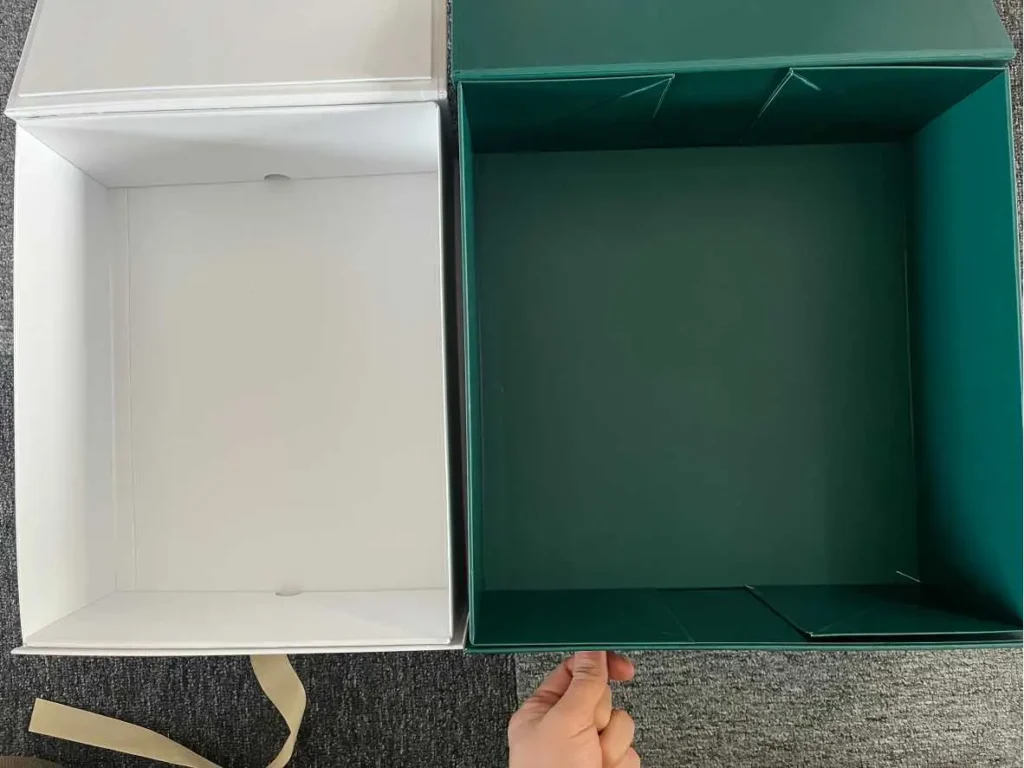 Side by side interior view of white snap-lock collapsible magnetic box and green adhesive tape magnetic folding box showing structural difference