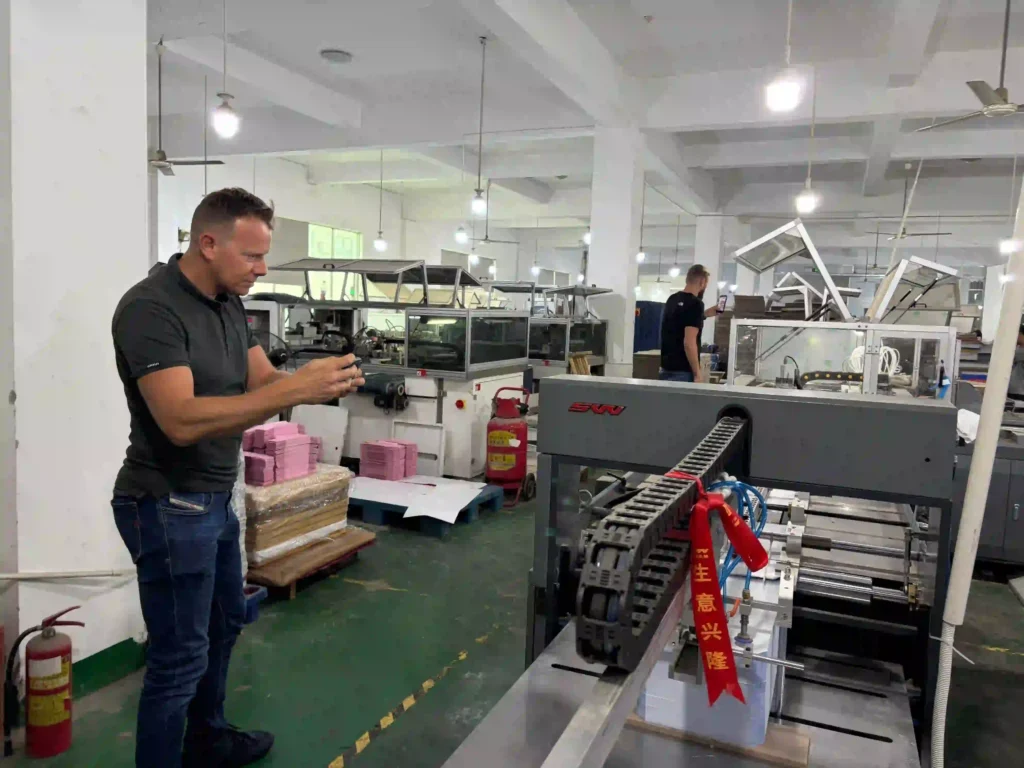 UK client inspecting automated packaging lines at ZY Pack factory Steven Legon from TDI Tuning UK visiting ZY Pack automated collapsible box production line.